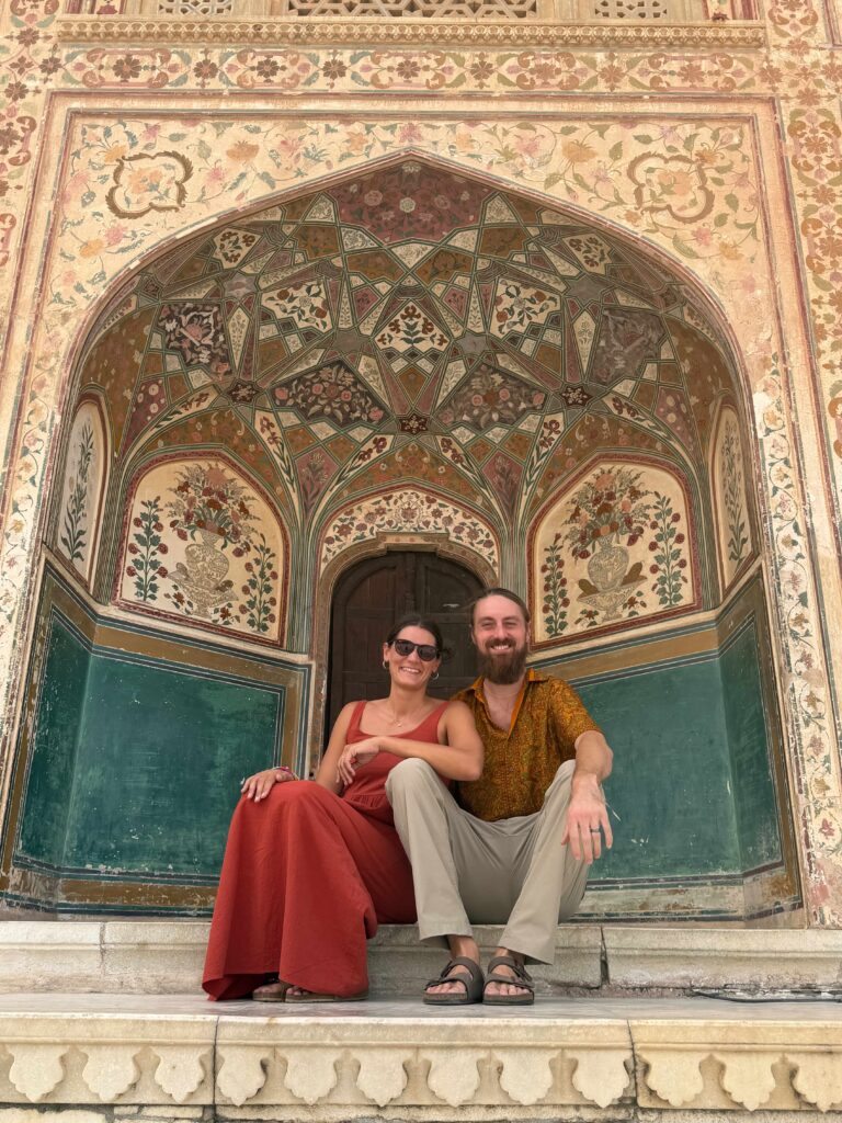 Couple sitting in ornate Mughal archway, India