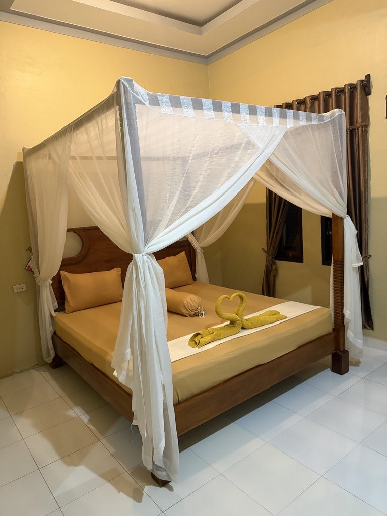 Canopy bed with mosquito net at jungle lodge on Sumatra orangutan trek