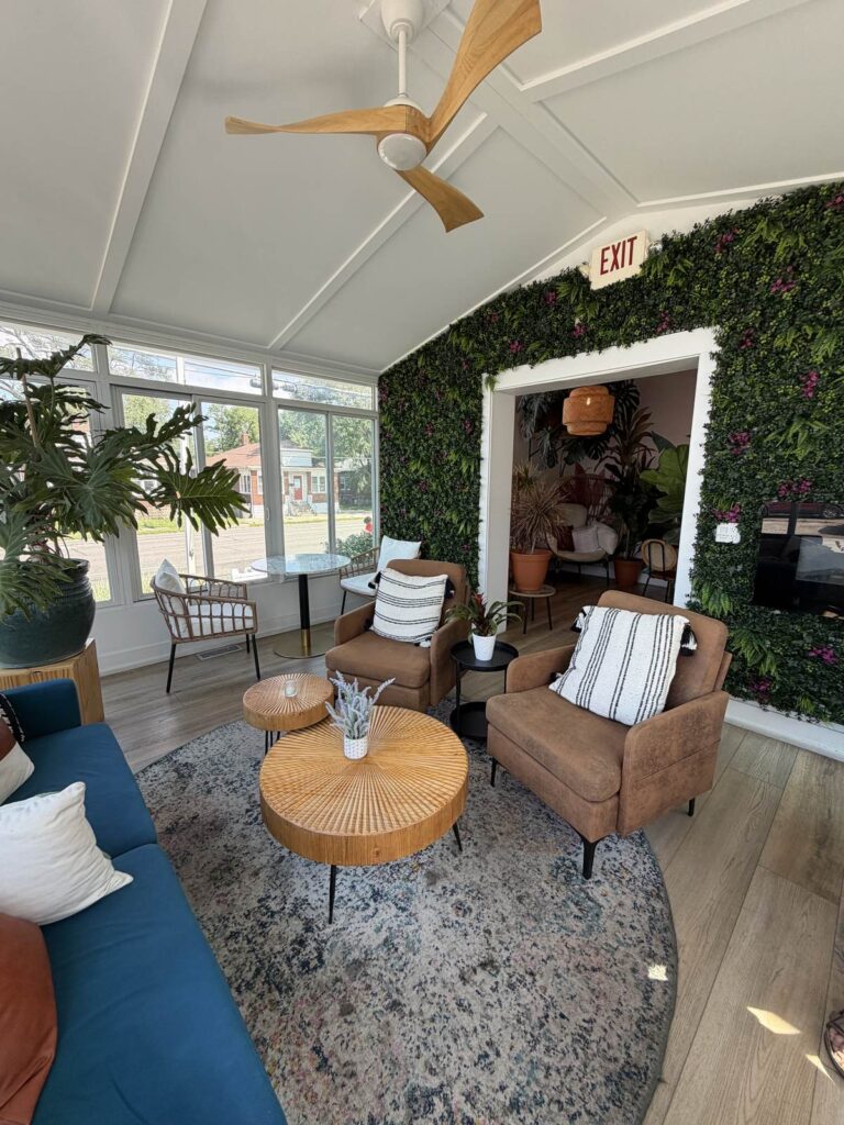 Plant-filled sunroom seating area at Issa Vibe Café in New Buffalo, Michigan