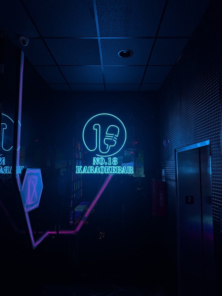 Glowing neon sign for No. 18 Karaoke Bar in Chicago's Chinatown